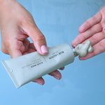 Model dispensing Algae Mask into hand from tube