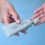 Model dispensing Algae Mask into hand from tube