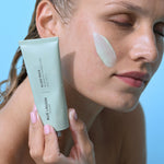 Model with Lava Algae Mask applied to cheek holding tube