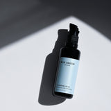 Hydrating Cream bottle with pump on light surface with shadow
