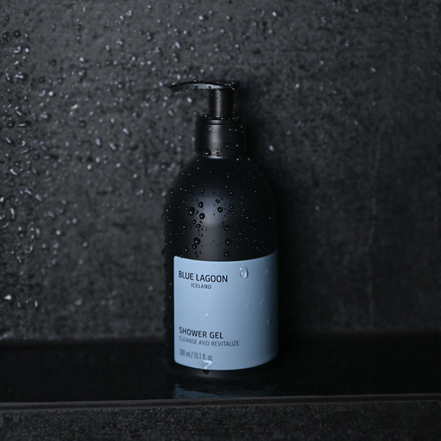 Shower Gel pump bottle standing on wet stone surface in shower setting