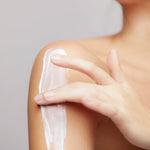 Model applying Mineral Moisturizing Cream on shoulder
